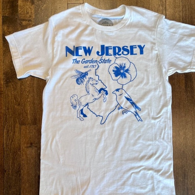 White t-shirt with blue font reads "New Jersey. The Garden State est.1787" across the chest. Under the words is an outline of the state, along with a flower, bird, horse and bee. 