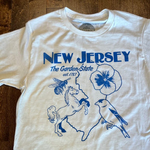 White t-shirt with blue font reads "New Jersey. The Garden State est.1787" across the chest. Under the words is an outline of the state, along with a flower, bird, horse and bee. 