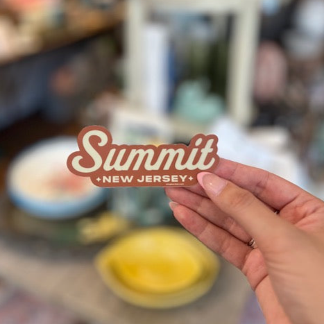 Hand holding a sticker that reads: Summit, New Jersey.