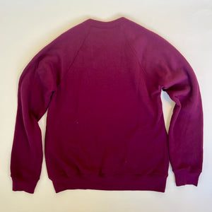 Backside of the maroon sweatshirt is blank. No prints or words.