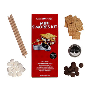 Red Rectangular packaging for a Mini S'mores Kit. Box reads: Indoor use. Makes 10. Includes: Mini marshmallows, Mini Chocolates, Mini Graham crackers, Mini indoor bonfire and toasting sticks. Surrounding the packaging are photos are the included items. 